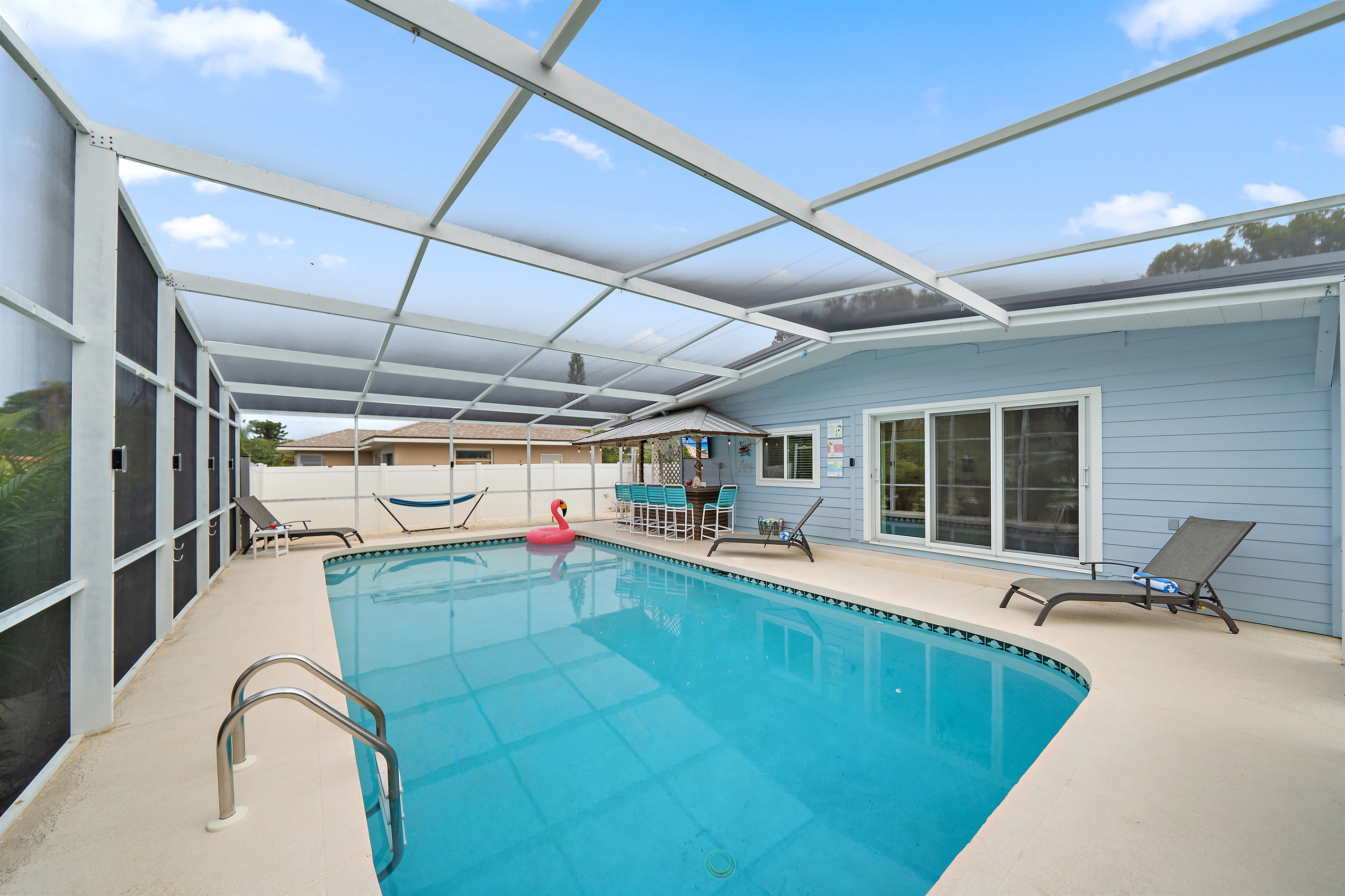 🌴 Your outdoor paradise — pool, tiki bar, hammock, screened lanai, and plenty of space to unwind.