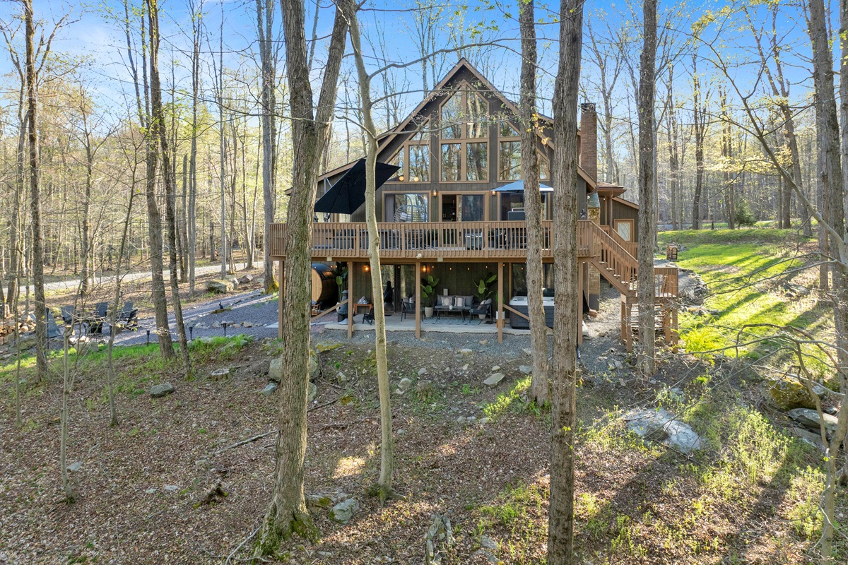 “Rear view of The Idyllic Pocono — surrounded by forest calm.”