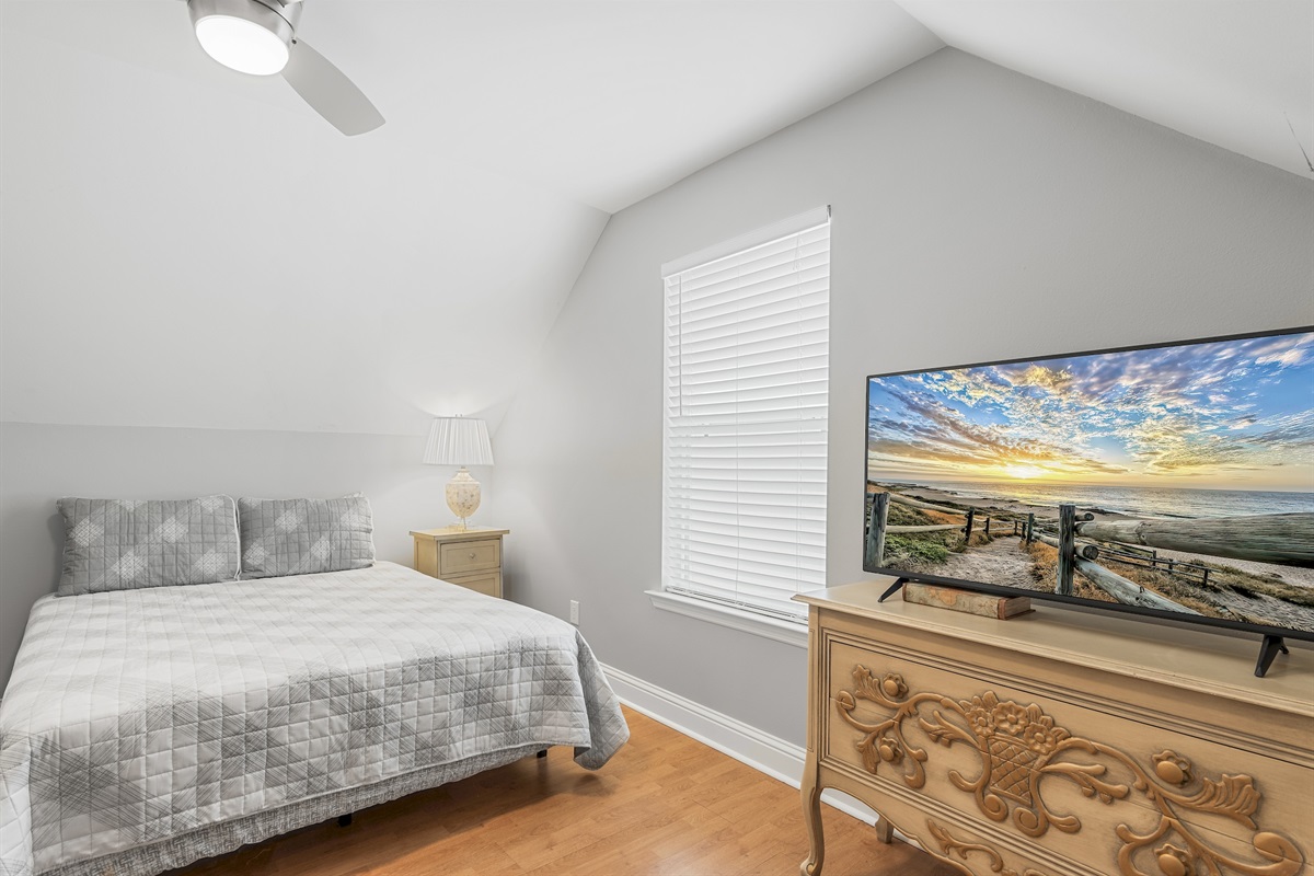 Guest queen bedroom with Smart TV and bright windows