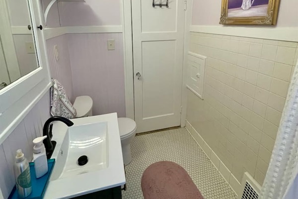 Charming bathroom featuring original tile floors paired with updated fixtures and a light, welcoming feel.