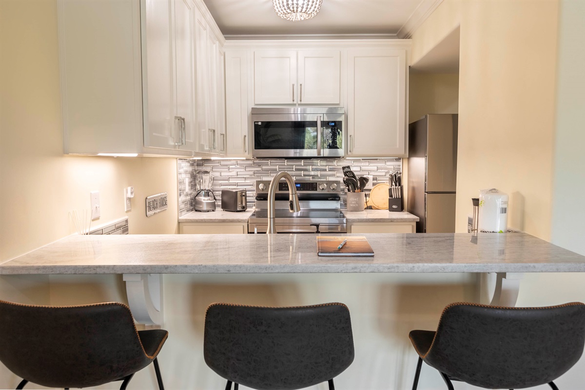 Modern cozy kitchen with sleek design, marble countertops, and warm lighting.