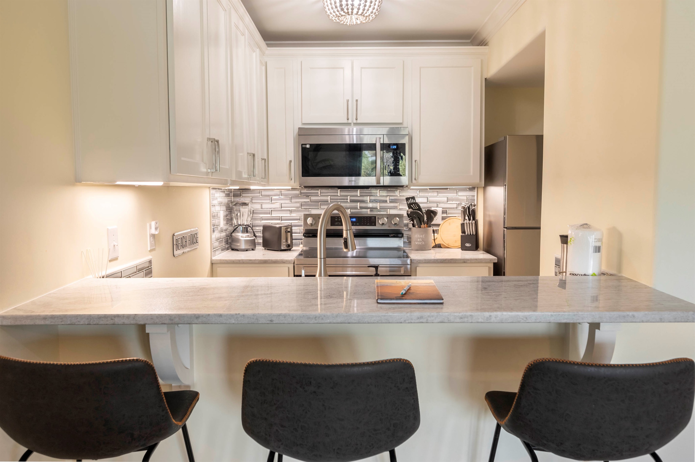 Modern cozy kitchen with sleek design, marble countertops, and warm lighting.