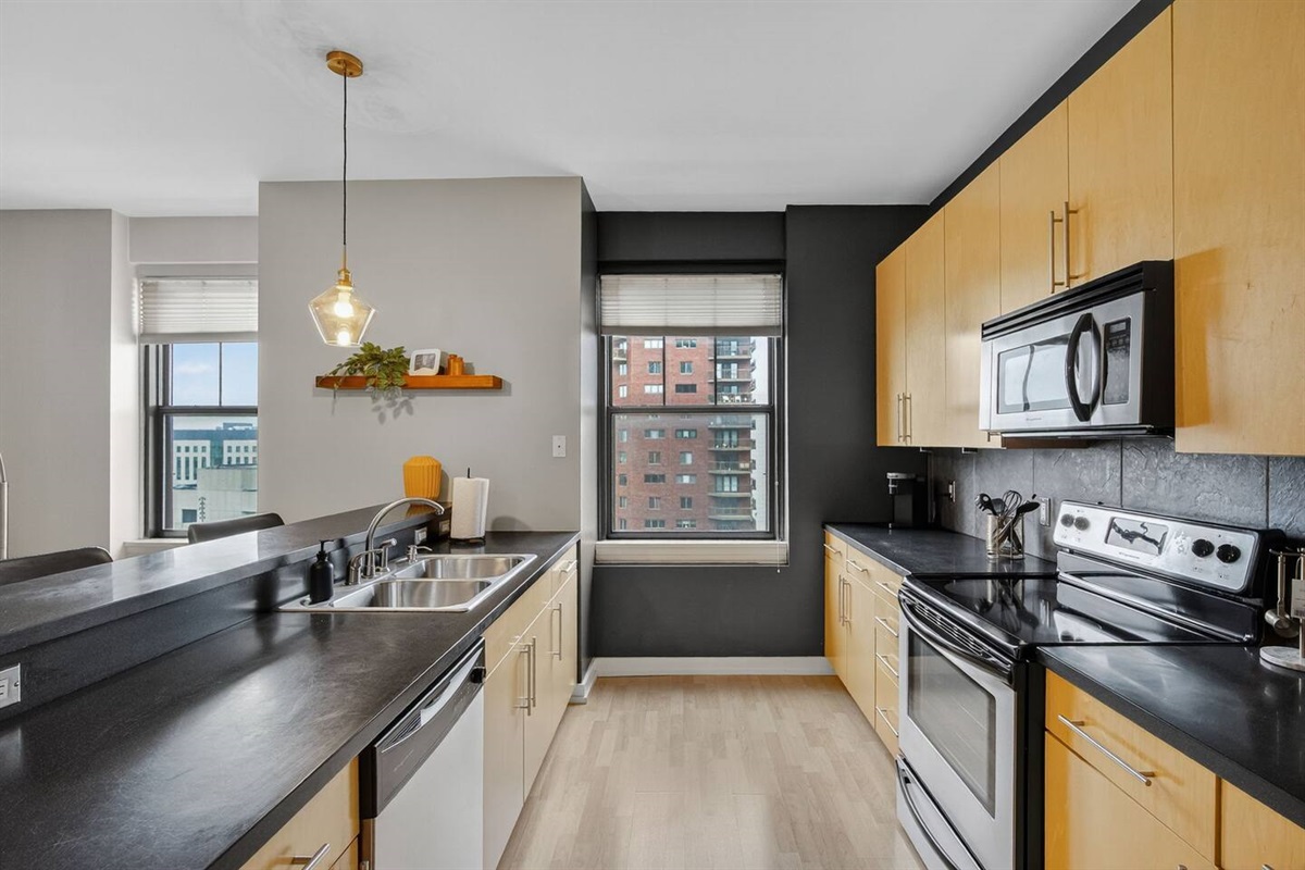 Whip up meals with a view—this spacious kitchen offers plenty of counter space, modern appliances, and bright windows framing the city skyline. Perfect for long stays or short city escapes.