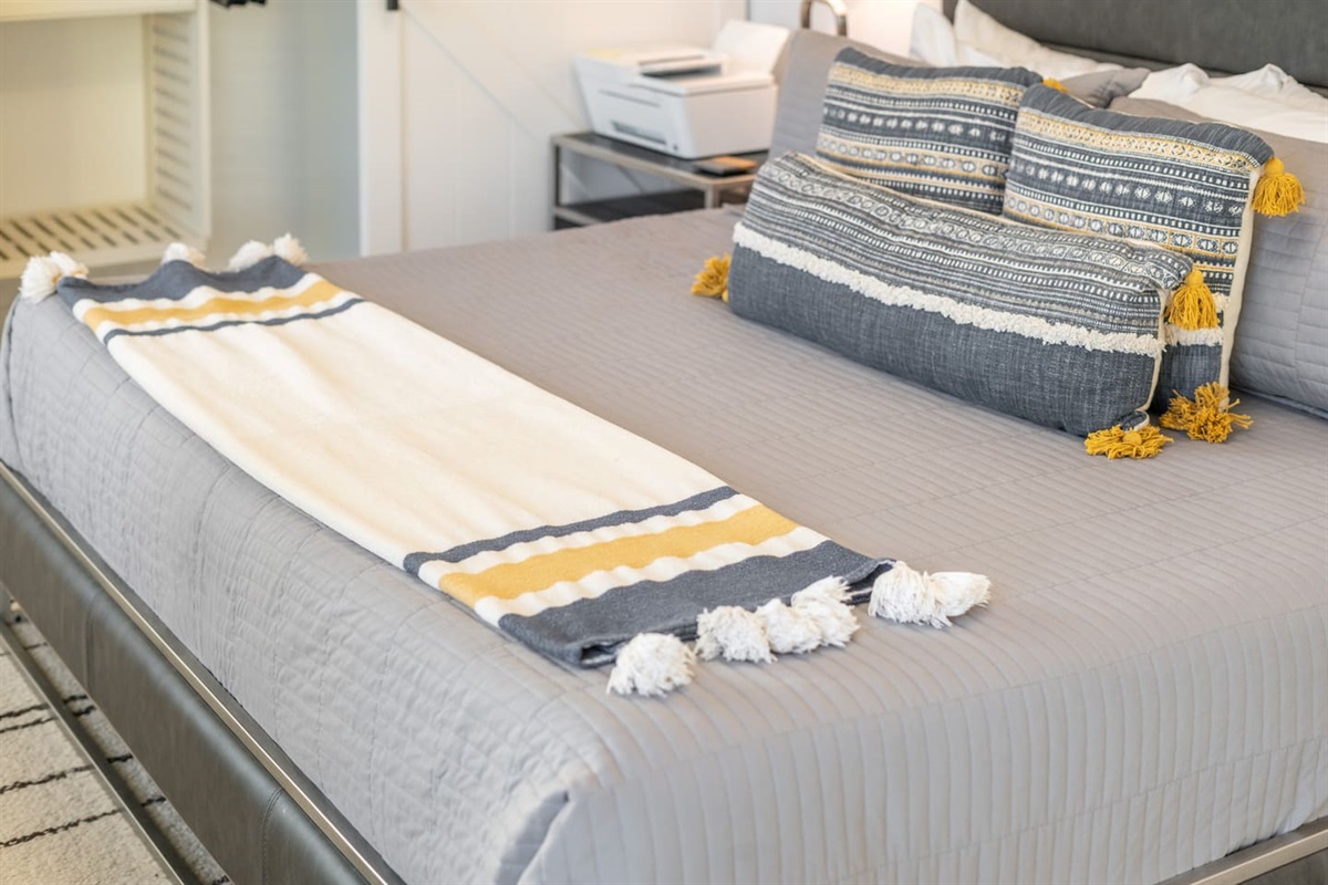 The simple yet warm accent throw complements the pillow colors, tying the room together with comfort and charm.

