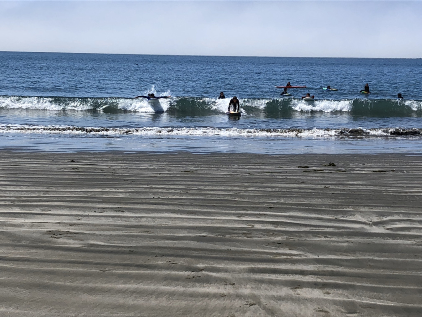 Surfers among small breaking waves