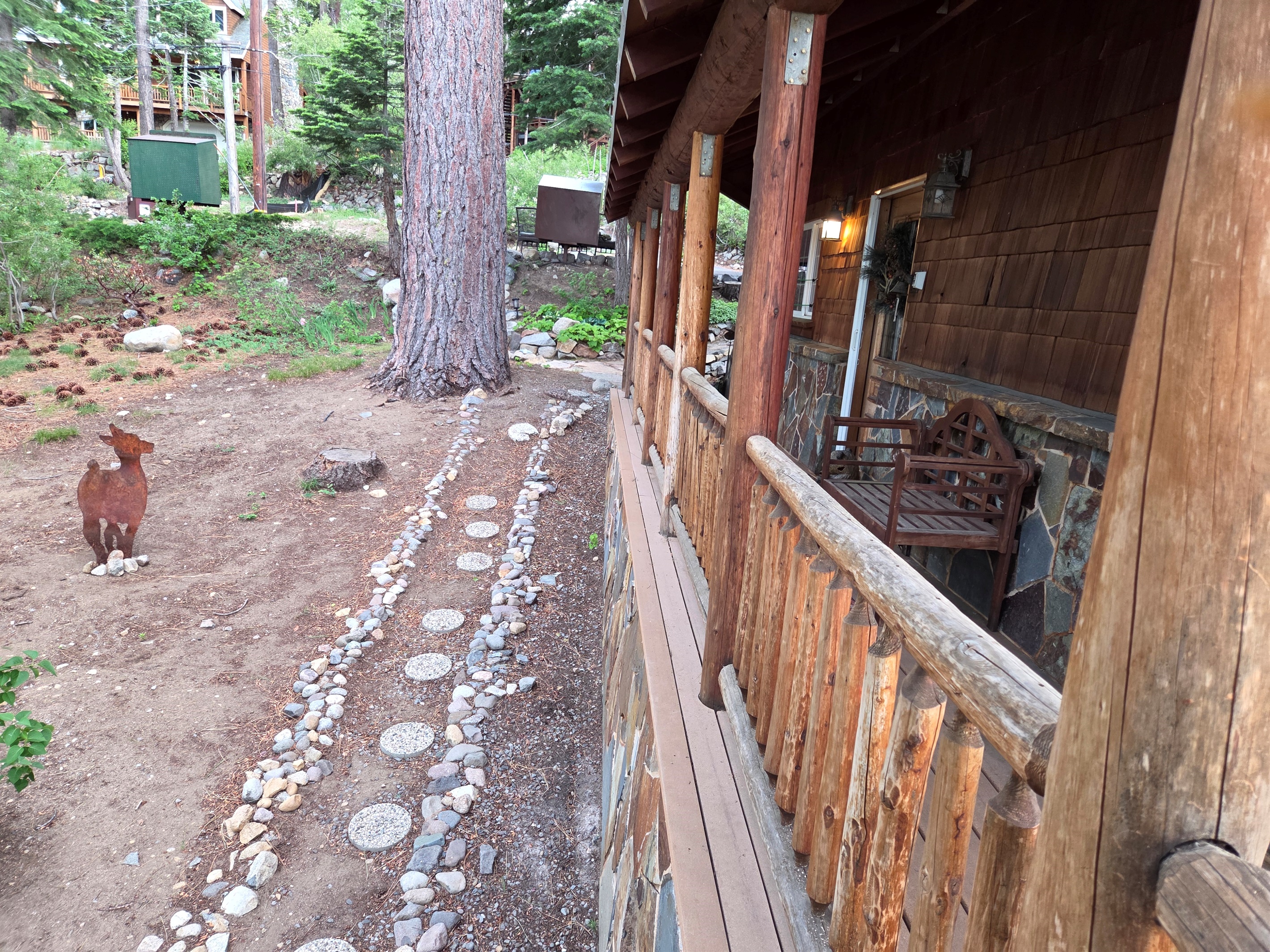 Our side deck and side yard area with rustic metal decor and stepping stones.  Out front doorway and entry to the house is covered to help protect from the elements.
