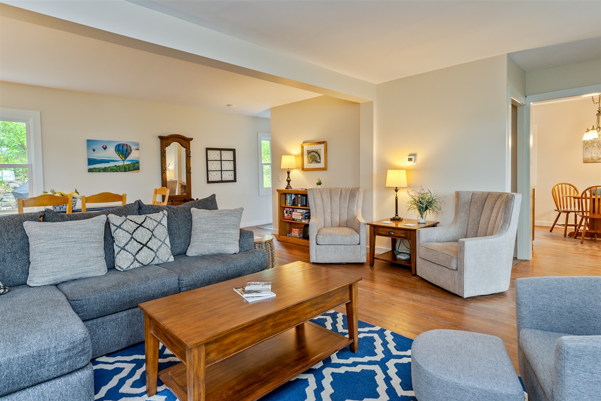 Gather with friends and family in a cozy living space featuring a large sectional, soft lighting, and a welcoming open layout.