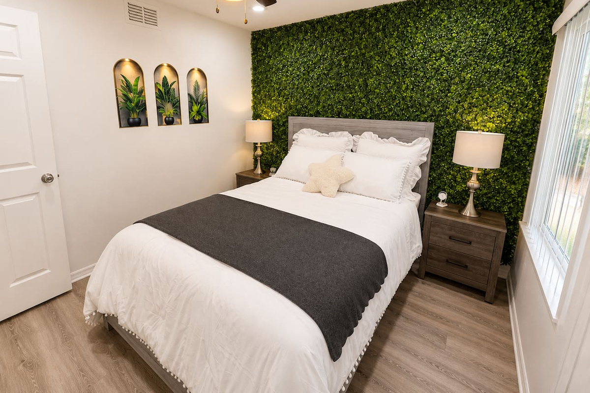 Inviting queen bedroom with a lush greenery-inspired accent wall.