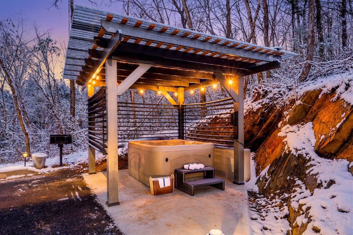 Private outdoor hot tub with pergola and adjustable slats for privacy.  Picnic style BBQ grill on the side.