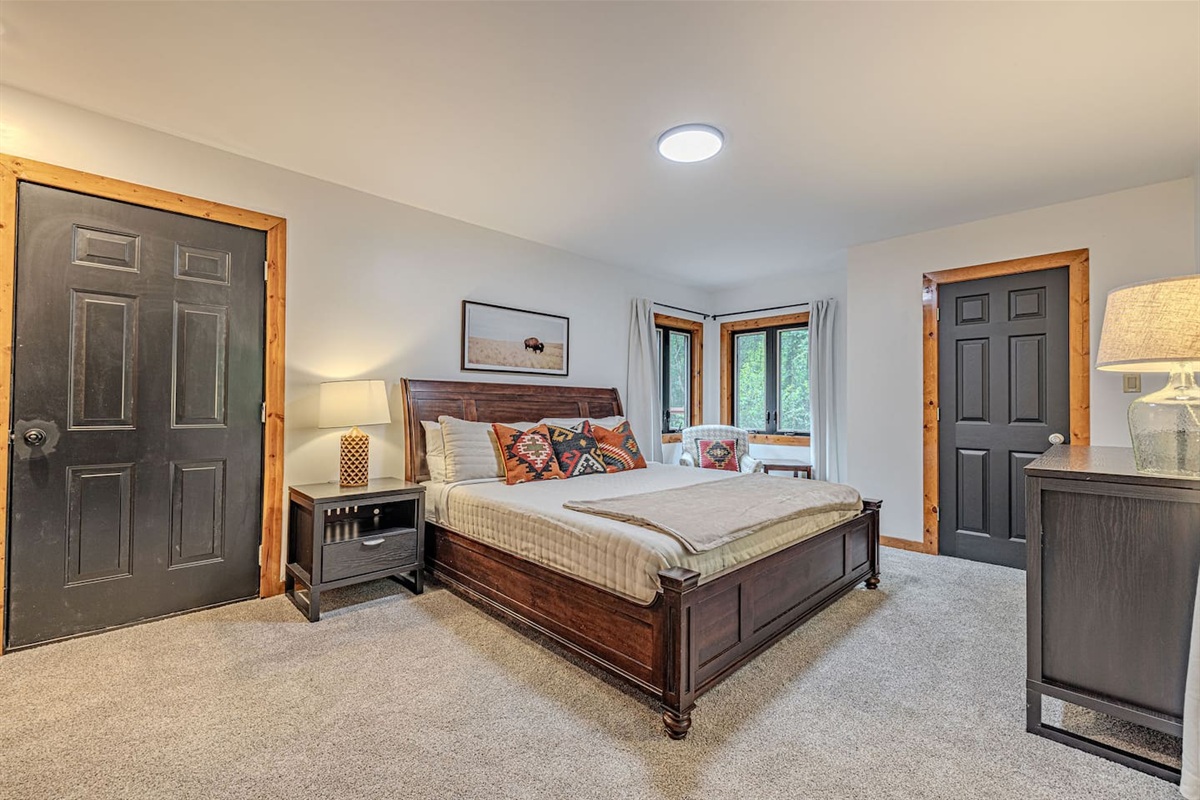 A beautifully appointed main-floor king bedroom featuring cozy seating, a Smart TV, and private access to the back deck and hot tub.  Your own secluded escape within the home.