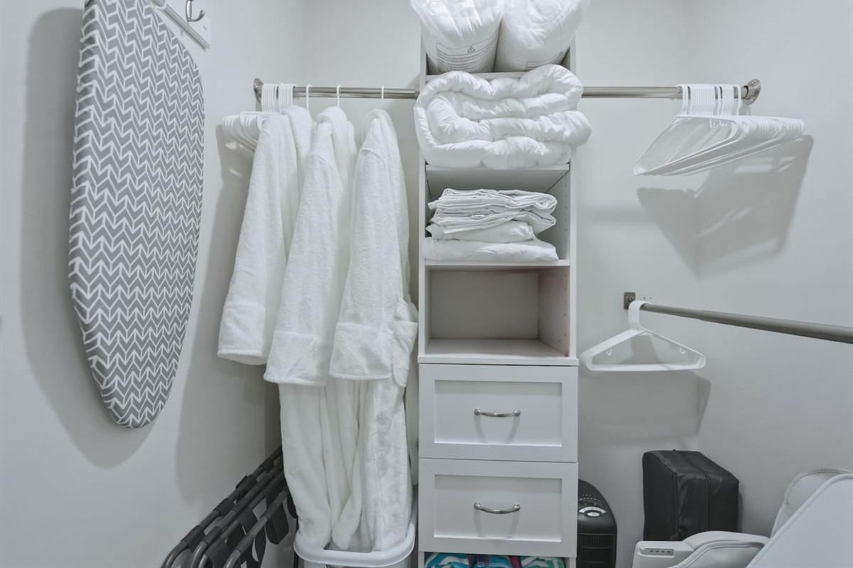 Walk-in closet stocked with hangers, extra linens, pillows, and a laundry basket to keep your stay organized and comfortable.
