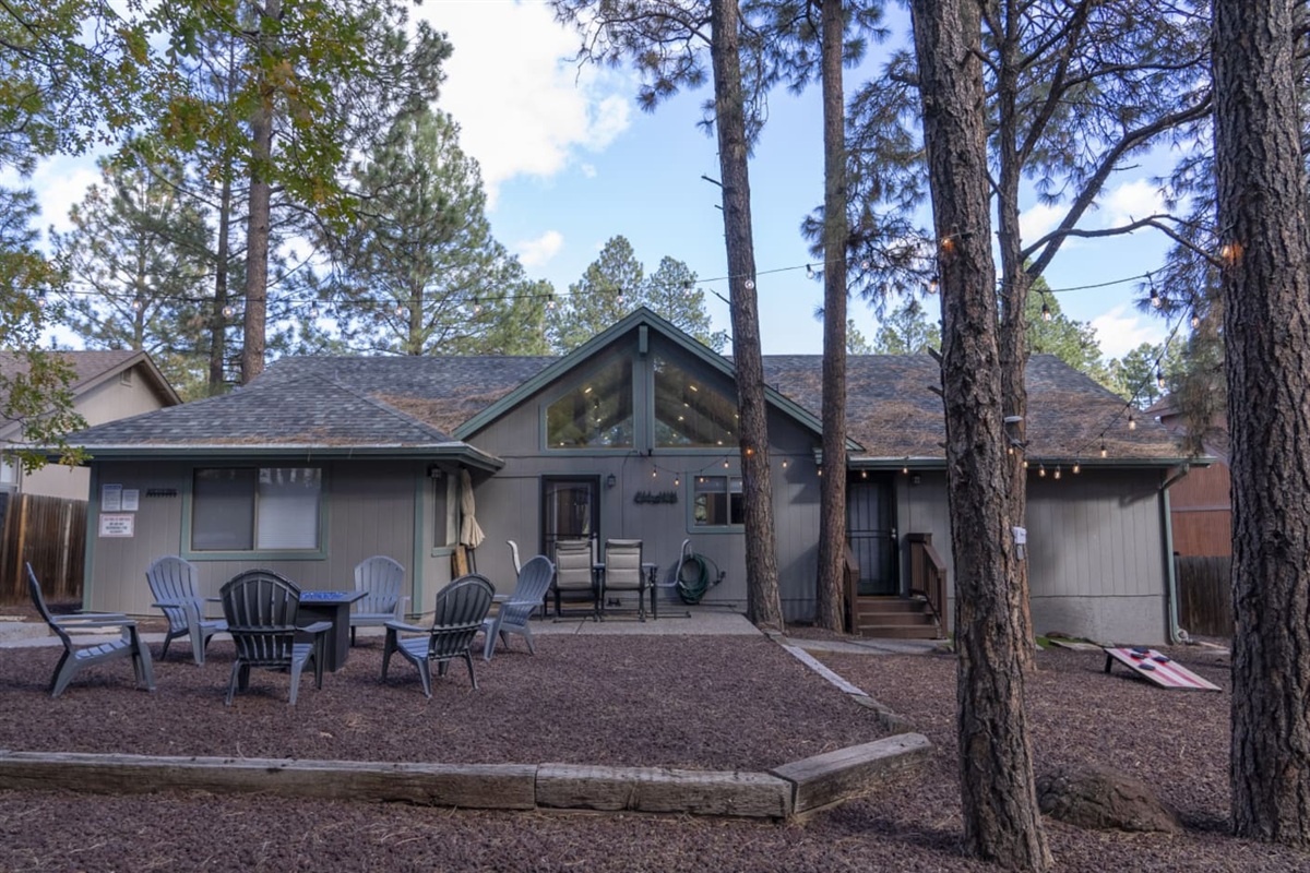 Outdoor space with pine trees, seating, and a peaceful setup for evenings outside.