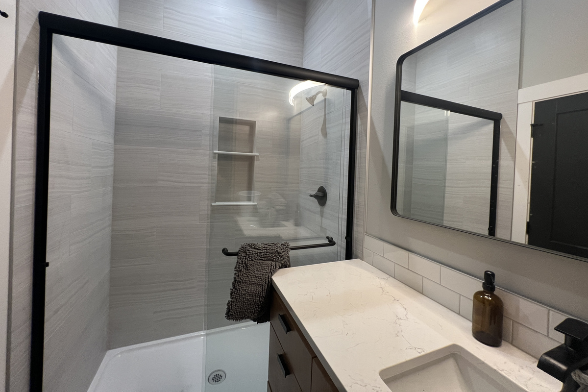 Another beautifully finished bath with a glass walk-in shower and quartz vanity — with this many bathrooms, nobody waits in line.