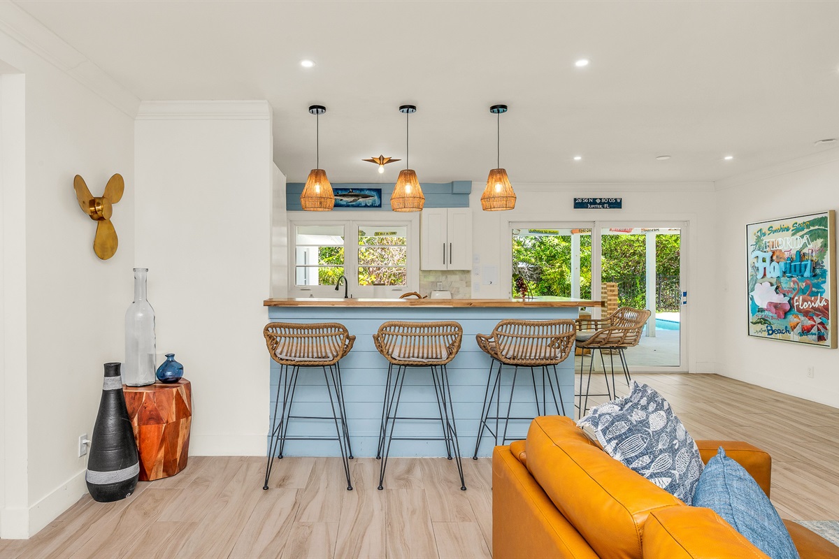 The fully stocked kitchen boasts a Sub-Zero fridge and acacia wood butcher block counters. A peninsula with seating provides the perfect spot for casual meals or morning coffee.