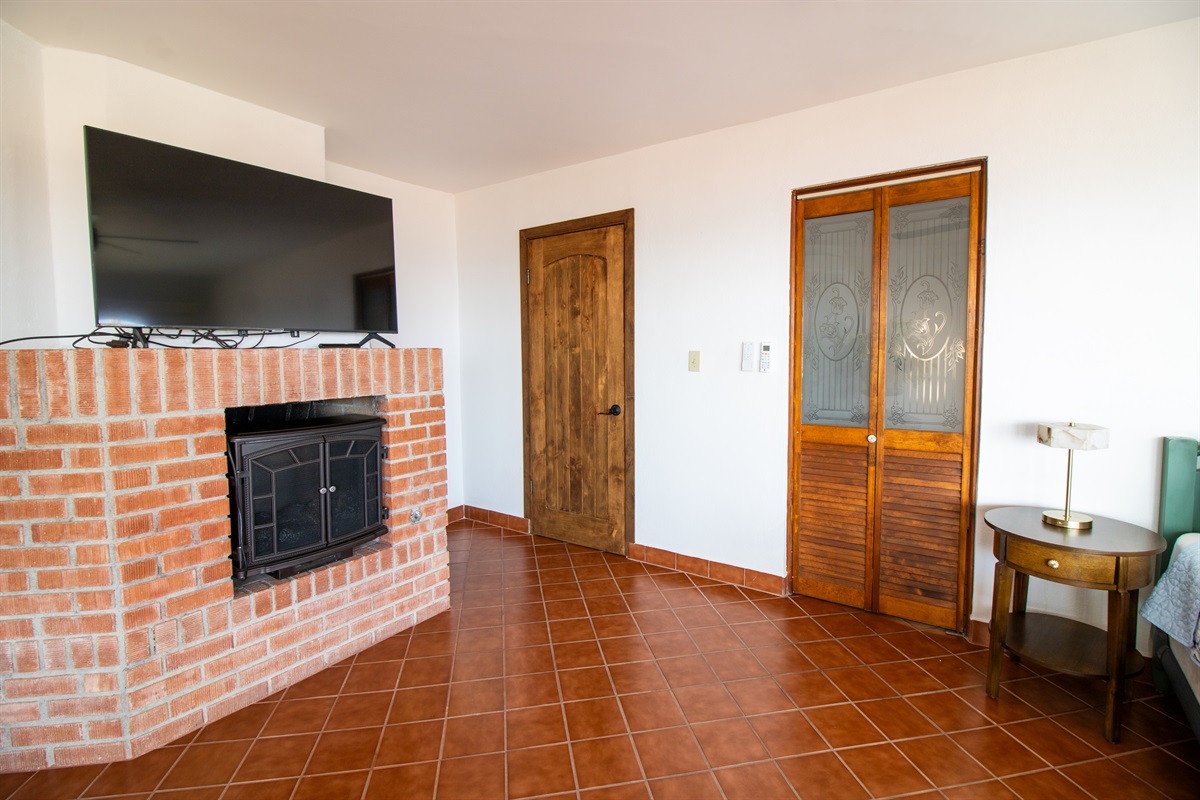 Principal Bedroom with King Bed, Fireplace, suite bathroom, and balcony.