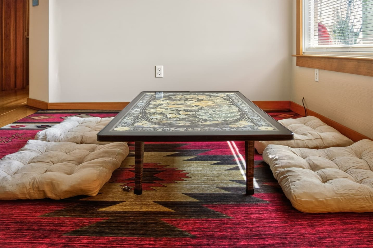 Relax in a Japanese-style living room with a low table, floor seating cushions, and warm, calming design—perfect for tea, conversation, or quiet moments, blending comfort and culture into a unique, peaceful retreat experience