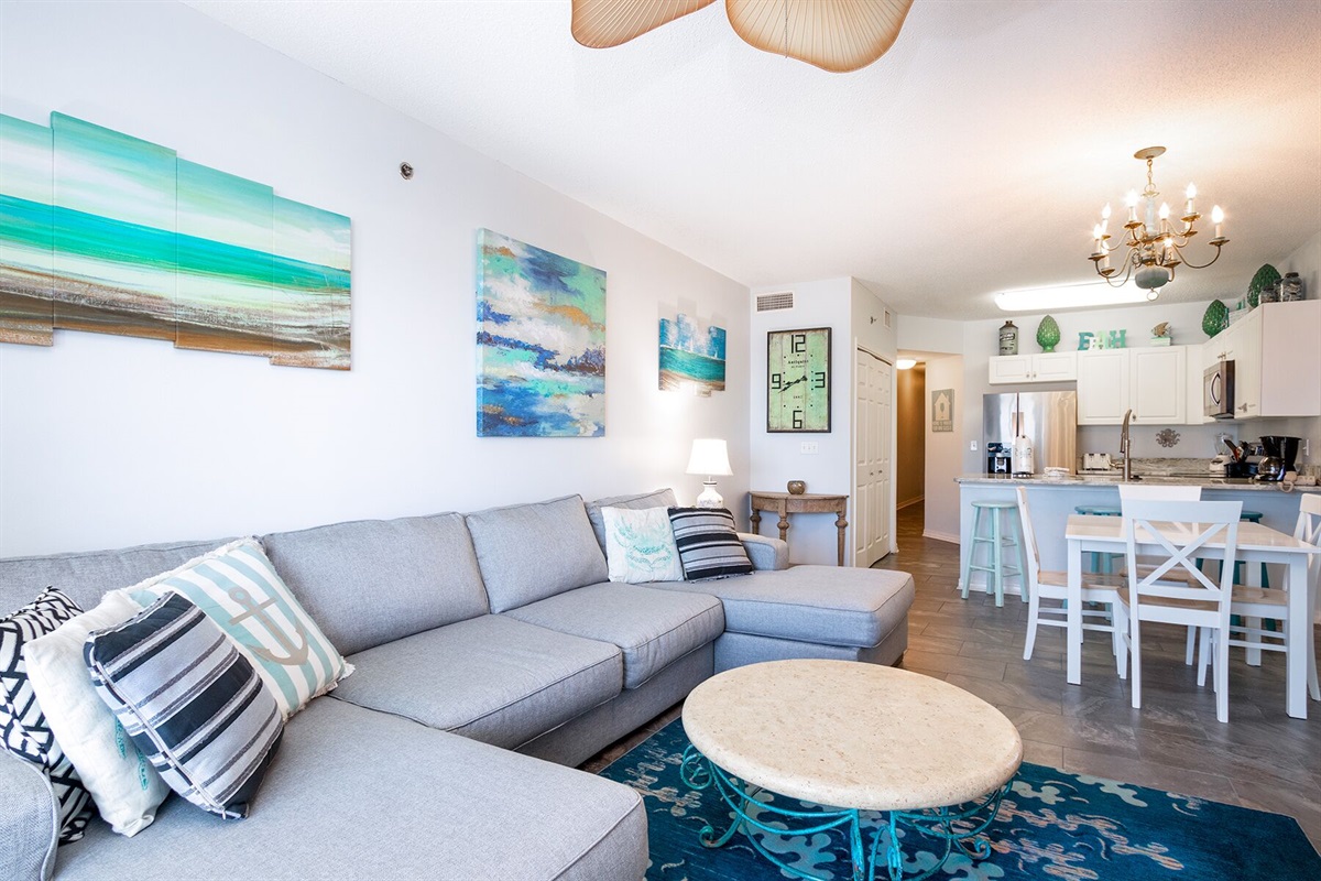 Living room with wall mounted smart TV, ceiling fan, sleeper sofa and balcony access with breathtaking view