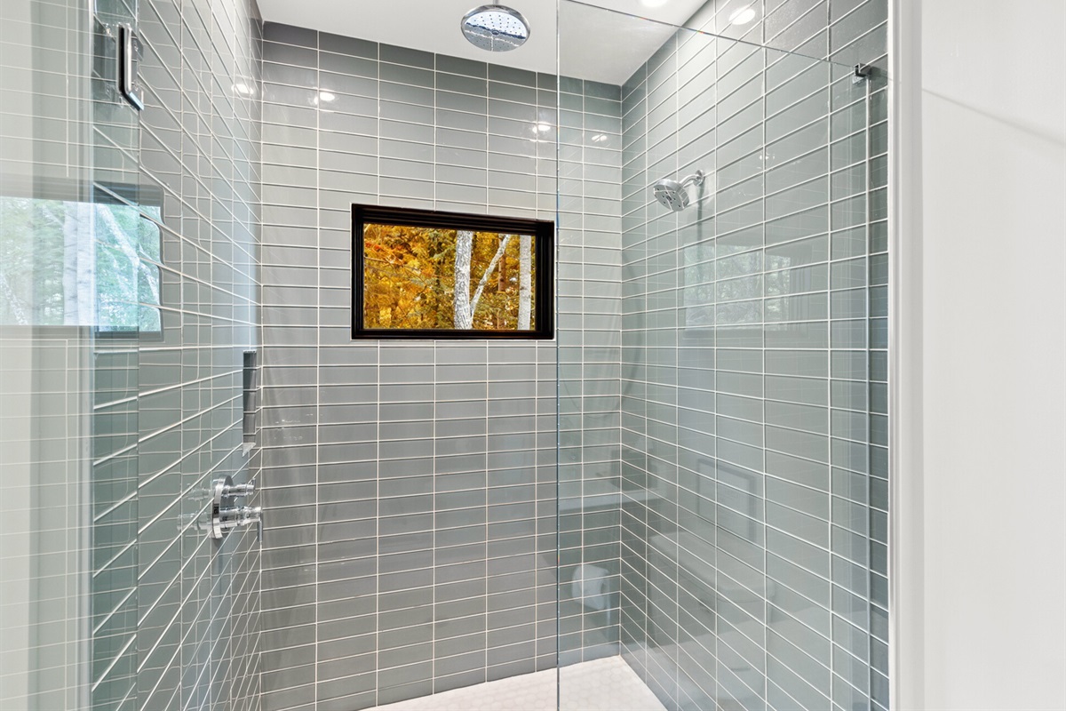 The tiled walk-in shower is a highlight of this bright and refreshing bathroom space.