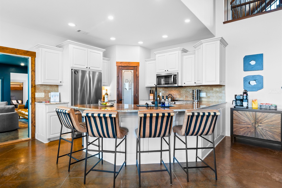 Bright white cabinetry, stainless appliances, and a generous island make this kitchen both beautiful and fully equipped for your stay.