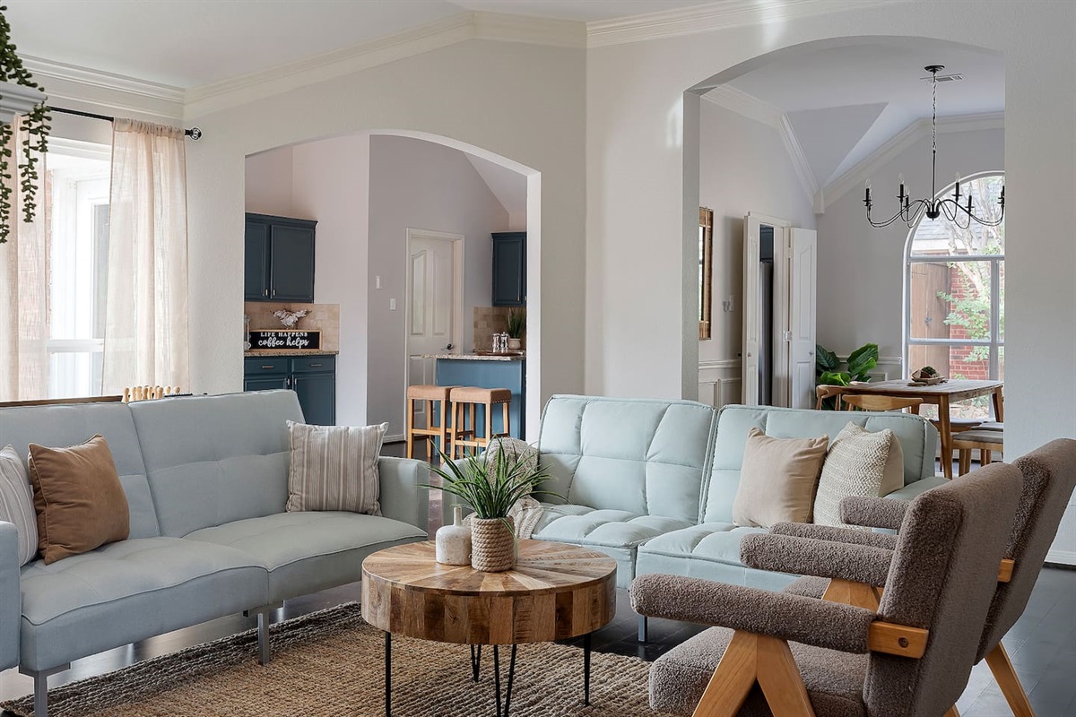 Welcome to our inviting living space with cozy sofas and a sleek TV setup.  Shaded windows bring in just the right amount of natural light, creating a perfect balance of comfort and ambiance.