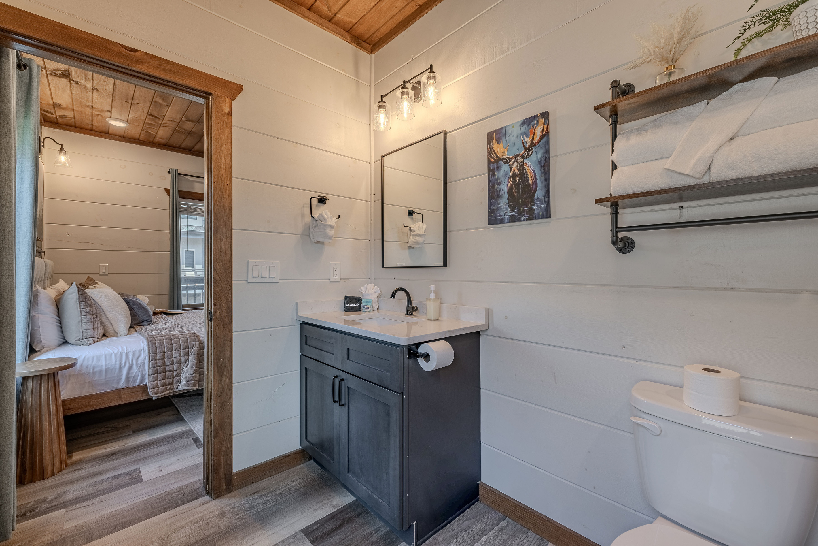 Full ensuite bathroom with vanity, shower combination, and convenient storage.