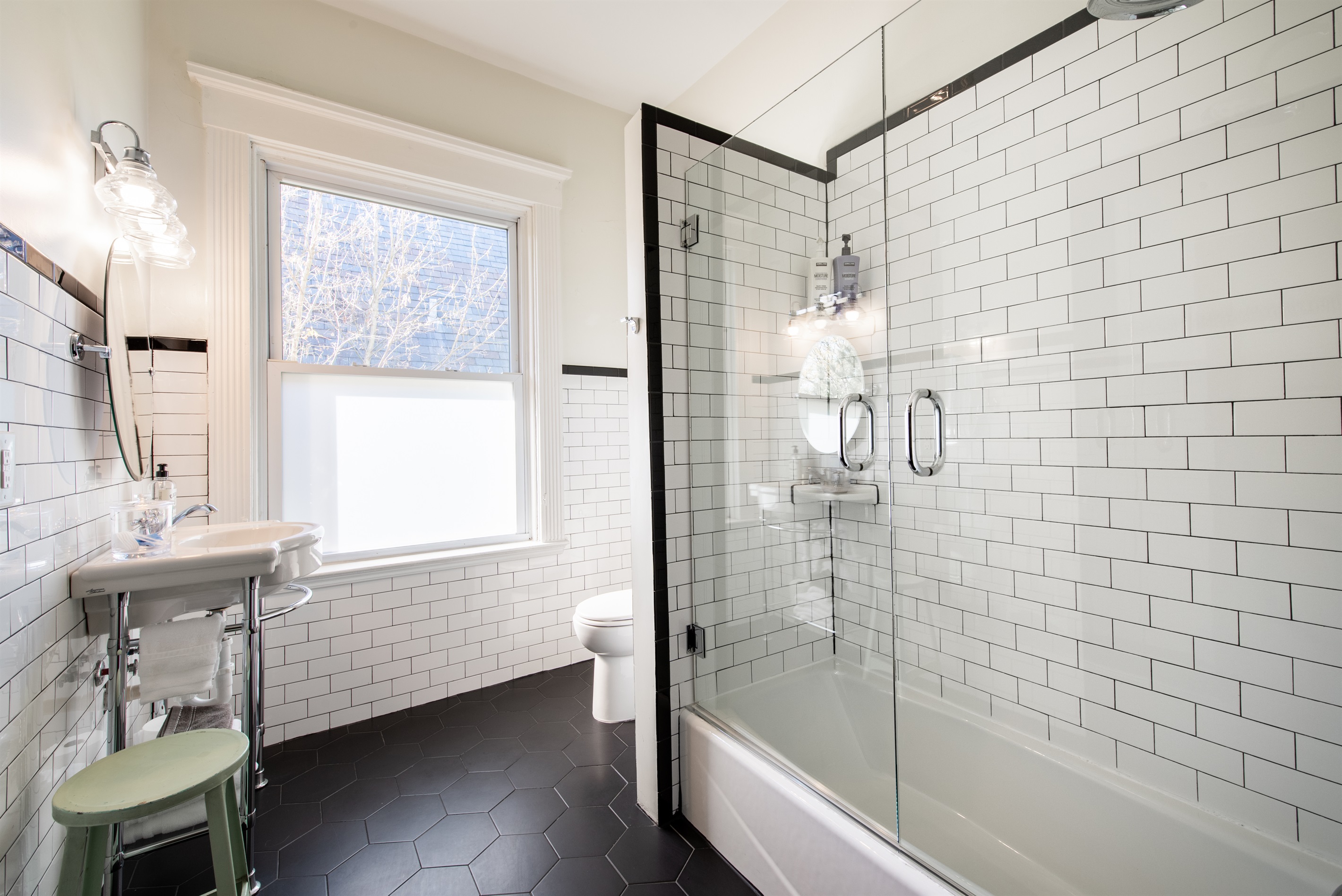 Refresh in this modern bathroom on the Bourbon Trail in Louisville’s Highlands! Features a sleek tub with shower, pedestal sink, and classic subway tiles—perfect for a relaxing stay.