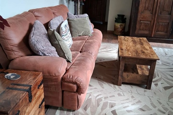 Reclining sofa in the second living area with the woodstove and massage chair and an armoire full of family friendly games and DVDs