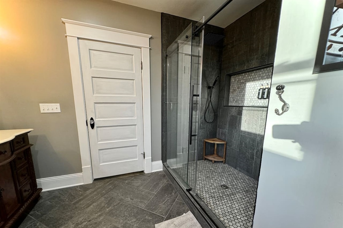 Shower with double rainfall shower heads and hand-helds in the Paris ensuite bathroom.