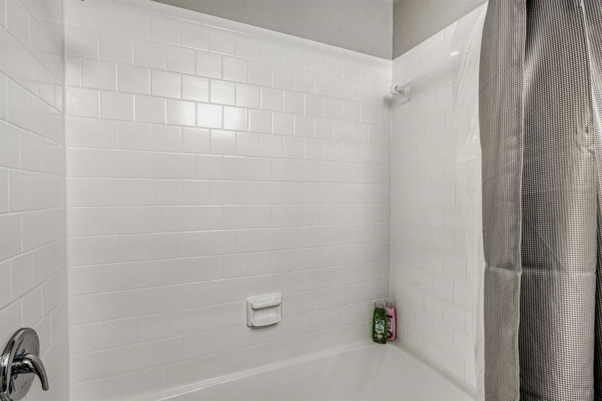 Clean white-tiled shower with a simple, modern look.