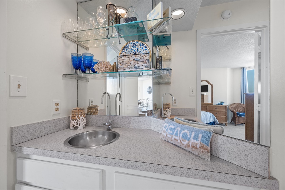 Coastal styled wet bar with glass shelving and a touch of beach inspired decor
