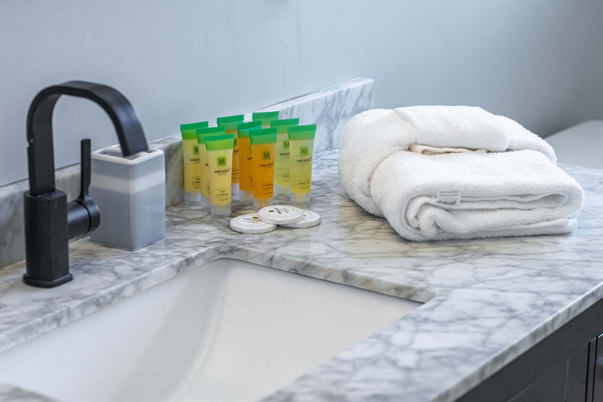 Simple yet inviting, this full bathroom includes a tub and shower combination setup, ample counter space, and a touch of retro character.