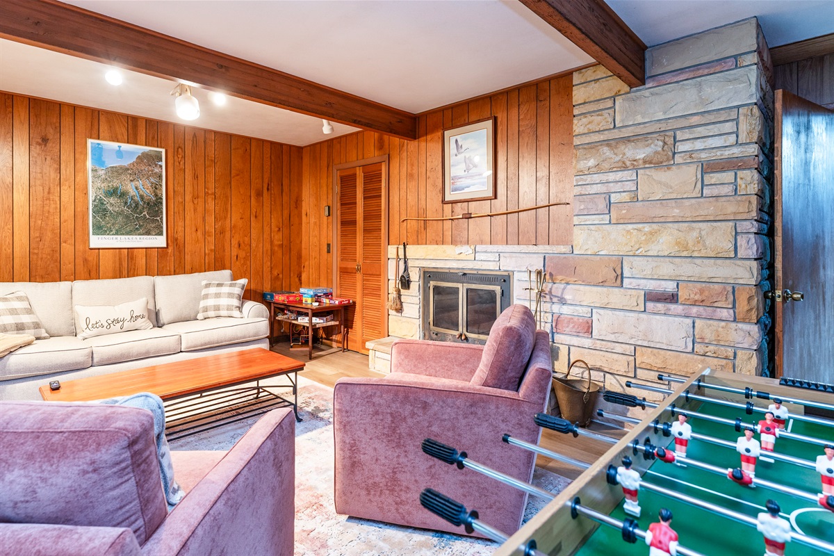 Fun-filled family room featuring foosball, plush seating, and sliding doors that open to the outdoors—ideal for game nights and relaxation.