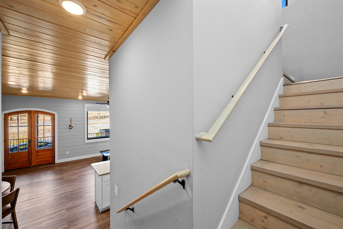 Stairway connecting levels of the home with solid railings and easy access between living spaces, bedrooms, and the loft.
