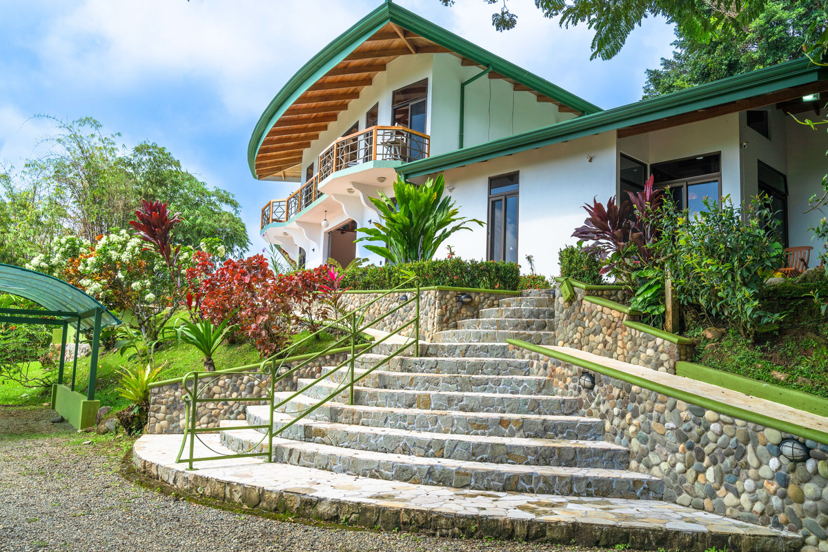Villa exterior entrance — stone steps, tropical landscaping, and welcoming arrival