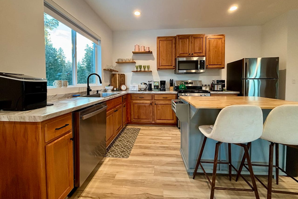 A clean, welcoming kitchen with thoughtful touches and a peaceful view of the trees. ✨