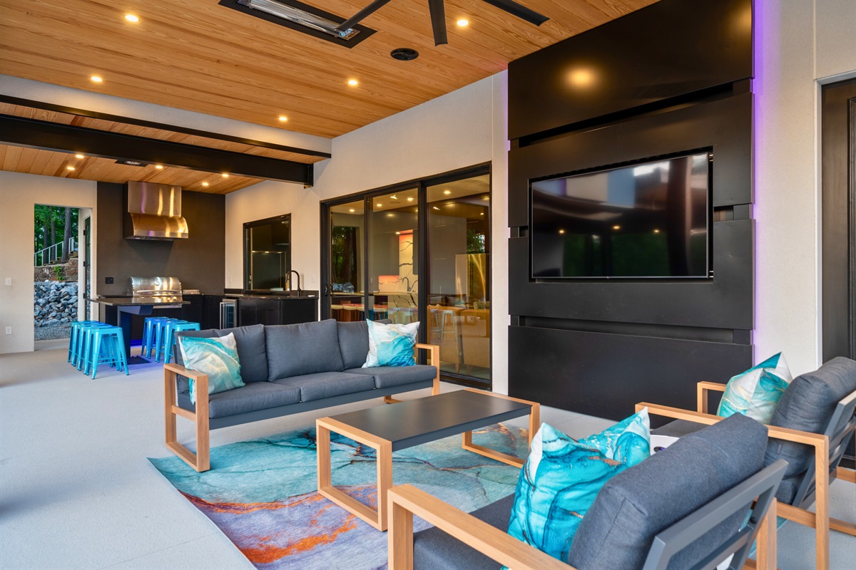 Enjoy the ultimate outdoor living experience with a cozy seating area, TV, and fireplace for year-round comfort.