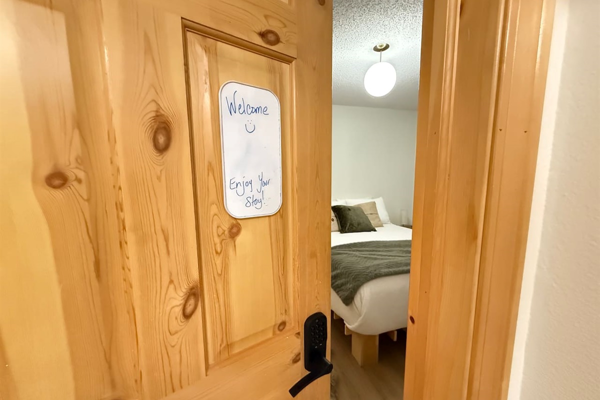 Main Floor Bedroom Entryway: View of the main floor bedroom entry and en-suite bathroom access, highlighting the natural wood accents.