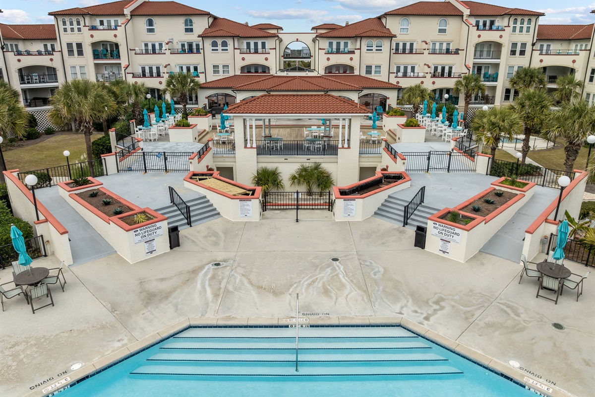 Expansive pool terrace with shaded pavilion and ocean-view lounging