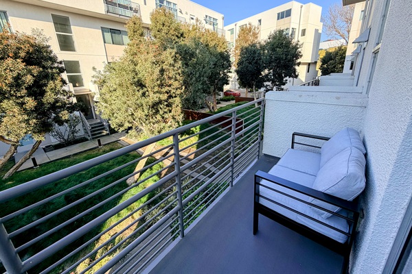 Balcony with seating and courtyard view.