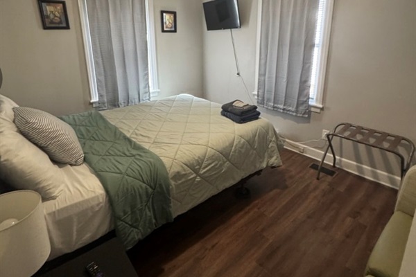 Queen bed with Smart TV and seating area 