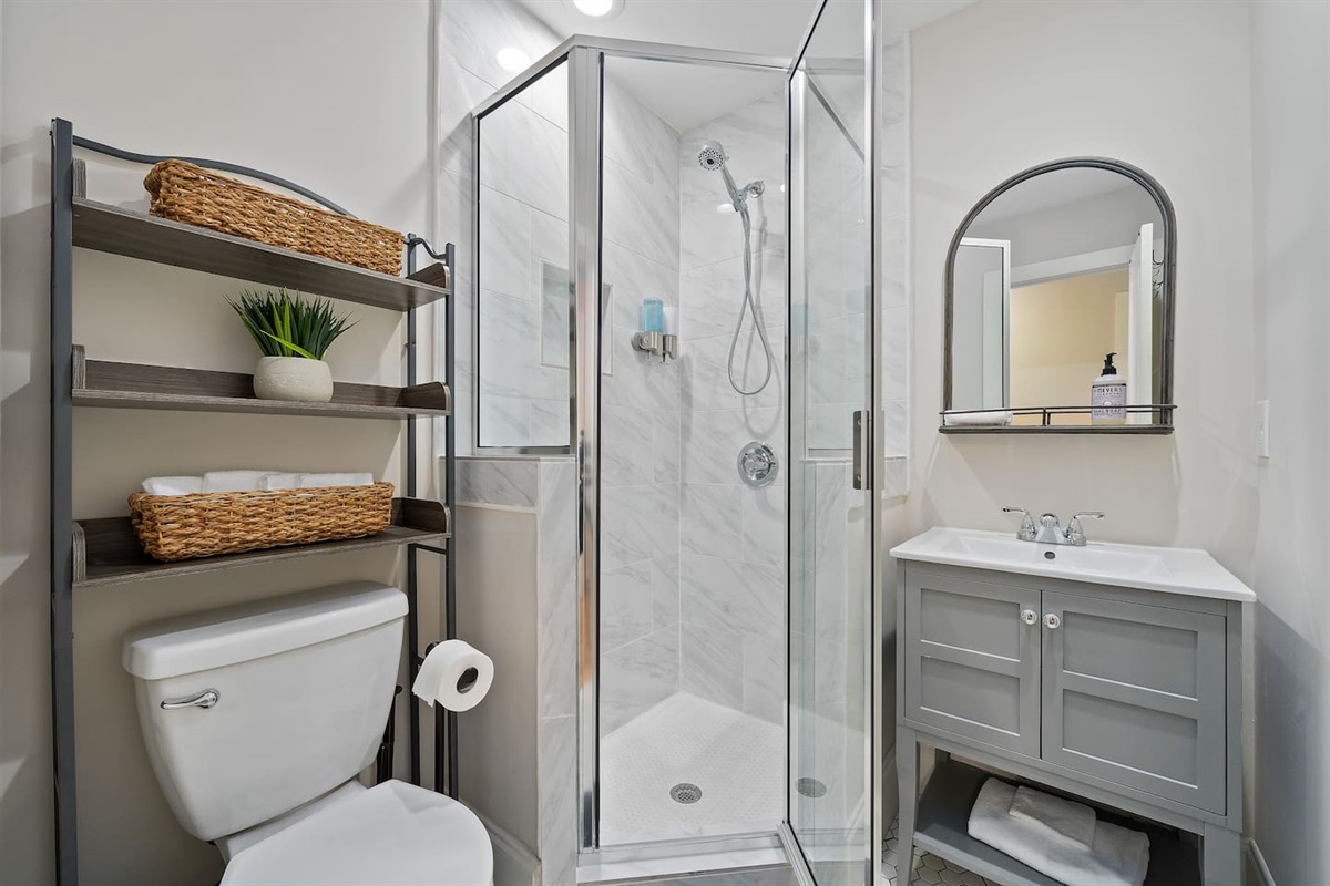 Showcases contemporary elegance with modern fixtures and a glass shower, enhancing your bathing experience.