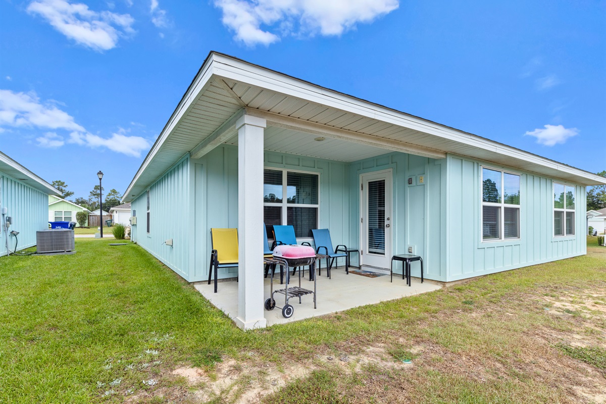 Covered back patio with seating to enjoy evening breezes or morning coffee outdoors.