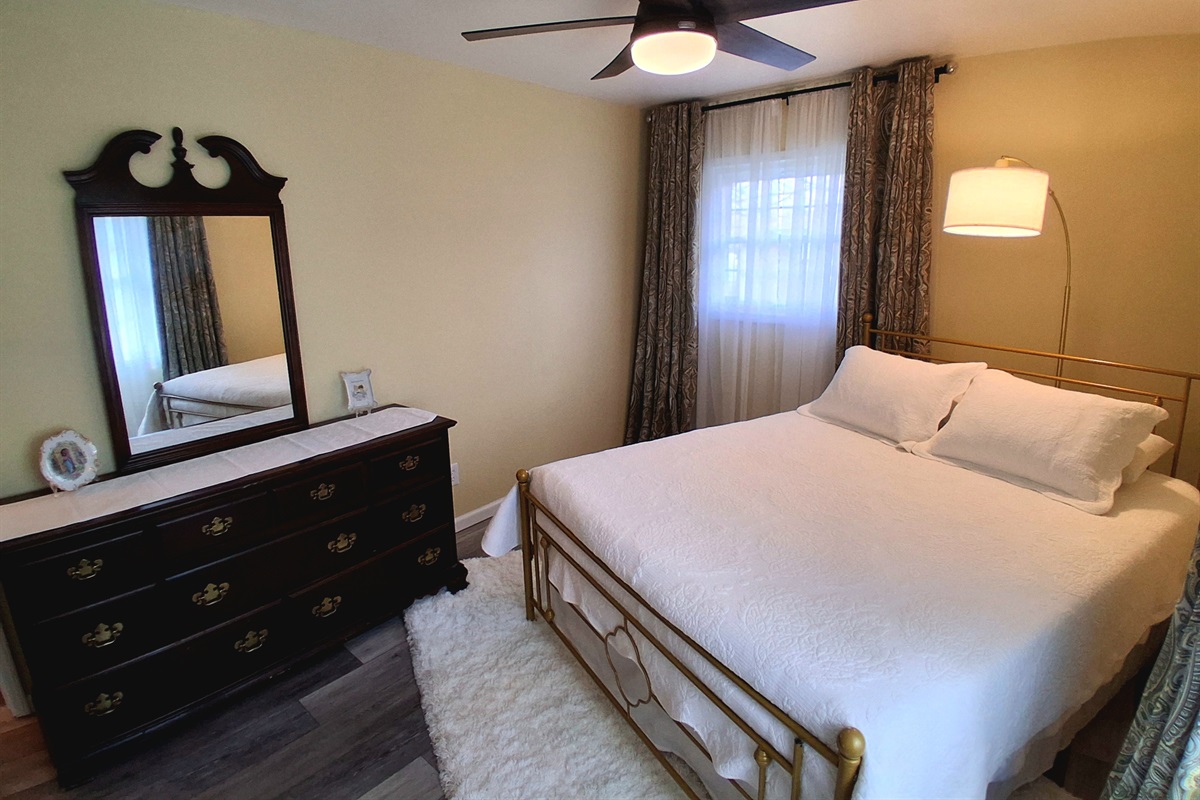 Both bedrooms offer privacy with their own lock and key. The cherry dresser provides generous drawer space, and the closet offers plenty of room for your belongings. A plush shag rug adds a cozy, welcoming touch underfoot.