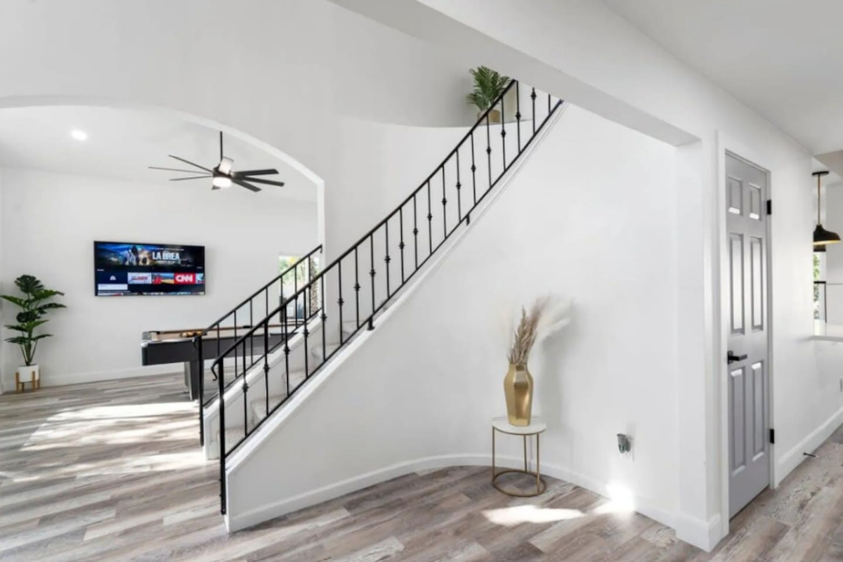 Bright, open staircase with modern railing, high ceilings, and contemporary design throughout.