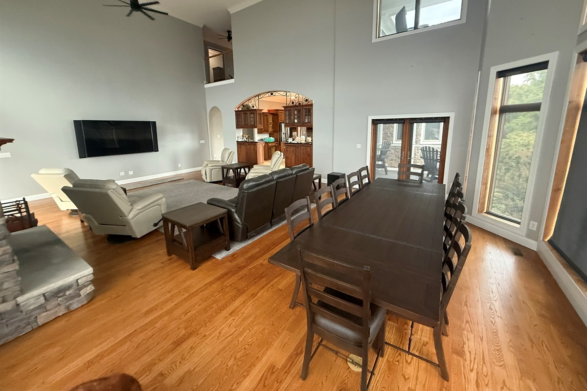 The living room is equipped with top-quality TV, a Stone wood-burning fireplace, and access to a back and front covered porch shared with the kitchen