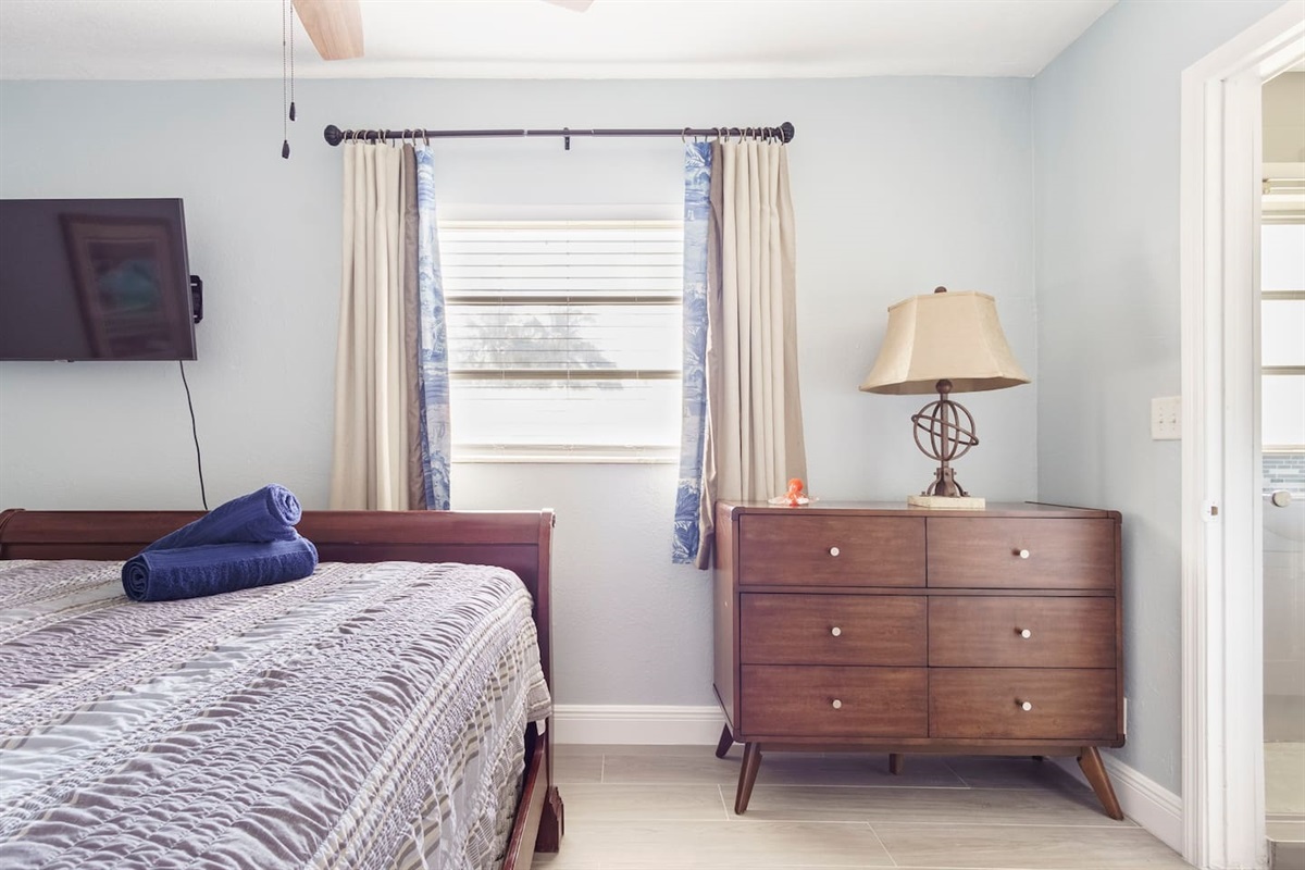 Bedroom 5 Queen bed, Smart TV, dresser, and walk in closet with shared bathroom.