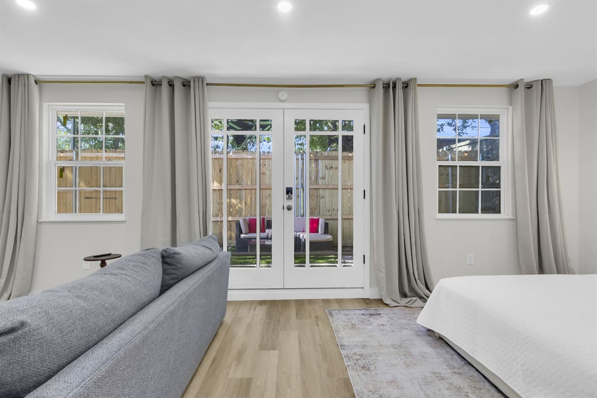 Bright and inviting living space featuring a plush sofa and king bed with direct views of the private patio.