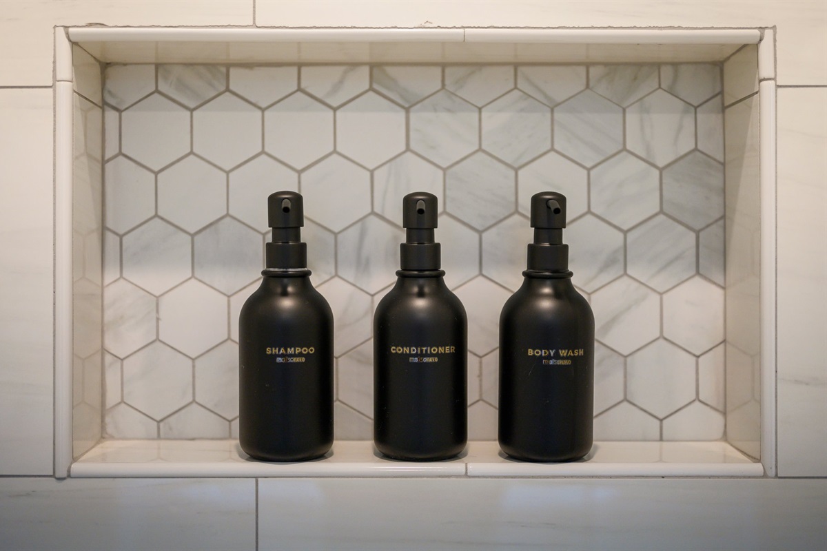 A built-in shower niche keeps premium toiletries neatly organized for a clean, spa-like experience.