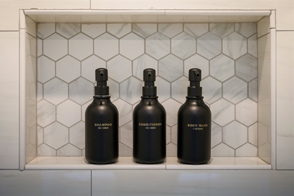 A built-in shower niche keeps premium toiletries neatly organized for a clean, spa-like experience.
