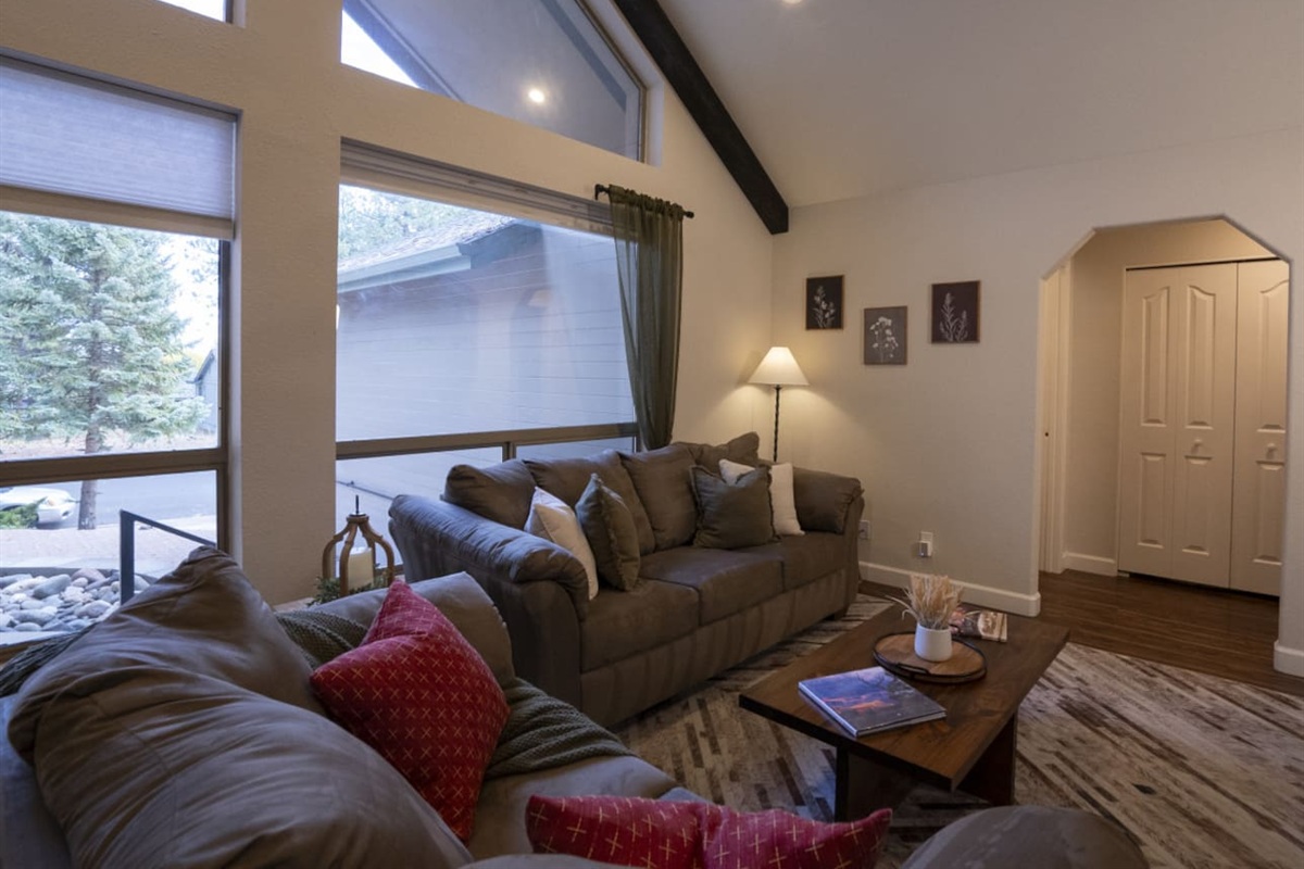 Open living space with tall windows, natural light, and a cozy setup for gathering after a day out.